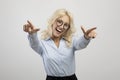 Overjoyed young businesswoman pointing at camera and smiling, aiming both fingers at viewer over light background Royalty Free Stock Photo