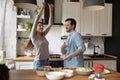 Happy young couple dancing while cooking at home kitchen Royalty Free Stock Photo