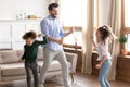 Overjoyed dad have fun dancing with little kids at home