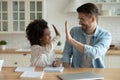 Caucasian father and ethnic daughter have fun studying together