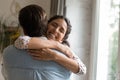 Overjoyed young woman embrace husband at home