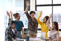 Overjoyed diverse employees celebrating business success or victory together in office. Royalty Free Stock Photo