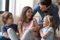 Overjoyed young family have fun relaxing together at home