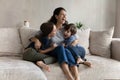 Overjoyed young hispanic mother having fun with laughing small kids.