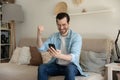 Overjoyed young man excited with win on cellphone