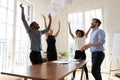 Overjoyed young multiracial team throwing papers in air. Royalty Free Stock Photo