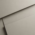 Overlapping sheets of beige textured paper arranged at slight angles. The paper has a Royalty Free Stock Photo