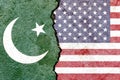 Overlay of the Pakistani and American flags on a weathered cracked wall background.