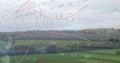Overlaying transparent stock charts and line graphs over fields in countryside, pylon, hedgerows Royalty Free Stock Photo