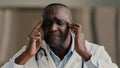 Overloaded tired exhausted sick man african american doctor physician works at hospital touch temples feel fatigue Royalty Free Stock Photo