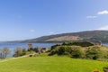 Urquhart Castle ruins stand overlooking Loch Ness, bathed in Scottish sun, amid lush greenery and gentle highland slopes Royalty Free Stock Photo