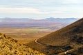 Overlooking the Indian Wells Valley with a dirt road winding around desert mountainsides under a hazy sky Royalty Free Stock Photo