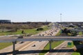 Overlooking an on and off ramp interstate highway exchange with multiple lanes below and blue sky