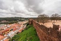 Overlooking the terracotta rooftops of a town from the ancient walls of Silves Castle under a