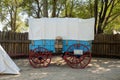 Overnight canvas tent beside a blue Prairie Schooner wagon