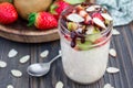 Overnight oatmeal with fresh strawberry and kiwi, garnished with chocolate sauce and sliced almond in glass jar Royalty Free Stock Photo