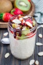 Overnight oatmeal with fresh strawberry and kiwi, garnished with chocolate sauce and sliced almond in glass jar Royalty Free Stock Photo