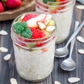 Overnight oatmeal with fresh strawberry and kiwi, garnished with sliced almond in glass jar, square format Royalty Free Stock Photo