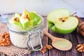 Overnight oats with matcha and green apples in a jar, close up on rustic wood