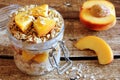 Overnight oats with peaches and granola on rustic wood