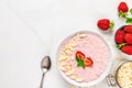 Overnight strawberry oats with fresh berries, almonds and mint in a bowl with a spoon on marble table. healthy breakfast