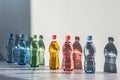 Overproduction and recycling concept - colorful water bottles on neutral background, direct light Royalty Free Stock Photo