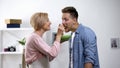 Overprotective mother feeding adult son with spoon, toxic relationship, problem Royalty Free Stock Photo