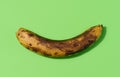 Overripe yellow banana on a green background, top view