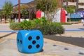 Oversize blue dice shaped chair with five dots at the playground. Blue huge gambling cube as a creative decision for urban