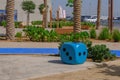 Oversize blue dice shaped chair at the playground. Blue huge gambling cube as a creative decision for urban furniture