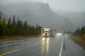 An oversize load truck carrying a prefabricated mobile home in extremely bad weather on a rainy day on a Canadian highway Royalty Free Stock Photo