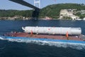 Oversized cargo transportation along the river, a distillation column on a barge floats to factory Royalty Free Stock Photo