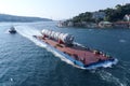 Oversized cargo transportation along the river, a distillation column on a barge floats to factory Royalty Free Stock Photo