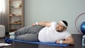 Oversized man lying at mat, doing physical exercises at home, burning weight