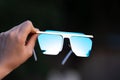 Oversized sunglasses hold by hand closeup. Selective focus