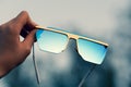 Oversized sunglasses hold by hand closeup. Selective focus