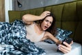 Oversleeping. Attractive young woman missed the ringing of the alarm clock and have overslept awakening and are late, reacting in Royalty Free Stock Photo