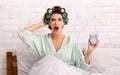 Shocked Woman Holding Clock Being Late Sitting In Bed Indoors Royalty Free Stock Photo