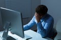 Overstressed businessman leaning at computer desk