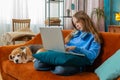 Overtired Caucasian teenage child girl bored using laptop doing a education project types lazily Royalty Free Stock Photo