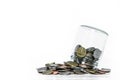 Overturn glass jar with coins spilled out, on white background