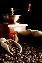 Overturned bag full of coffee beans on black with spatula,mill