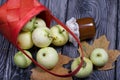 An overturned basket of apples. Nearby are jam, apples and dried maple leaves. Fruit harvest Royalty Free Stock Photo