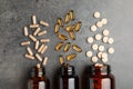 Overturned bottles with different dietary supplements on grey table, flat lay Royalty Free Stock Photo