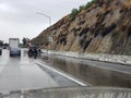 Overturned car and Highway Patrol on rain soaked freeway