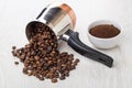 Overturned cezve with coffee beans, bowl with ground coffee Royalty Free Stock Photo