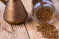 Overturned cezve with coffee beans, bowl with ground coffee on wooden table Royalty Free Stock Photo