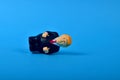 Overturned Donald Trump figure lying on a blue background with copy space