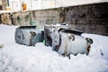 Overturned garbage containers during strong and snowy winter