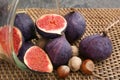 Overturned glass with fresh ripe figs and nuts on wicker tray Royalty Free Stock Photo